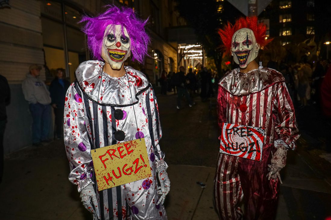 scary clowns with "free hugz" signs